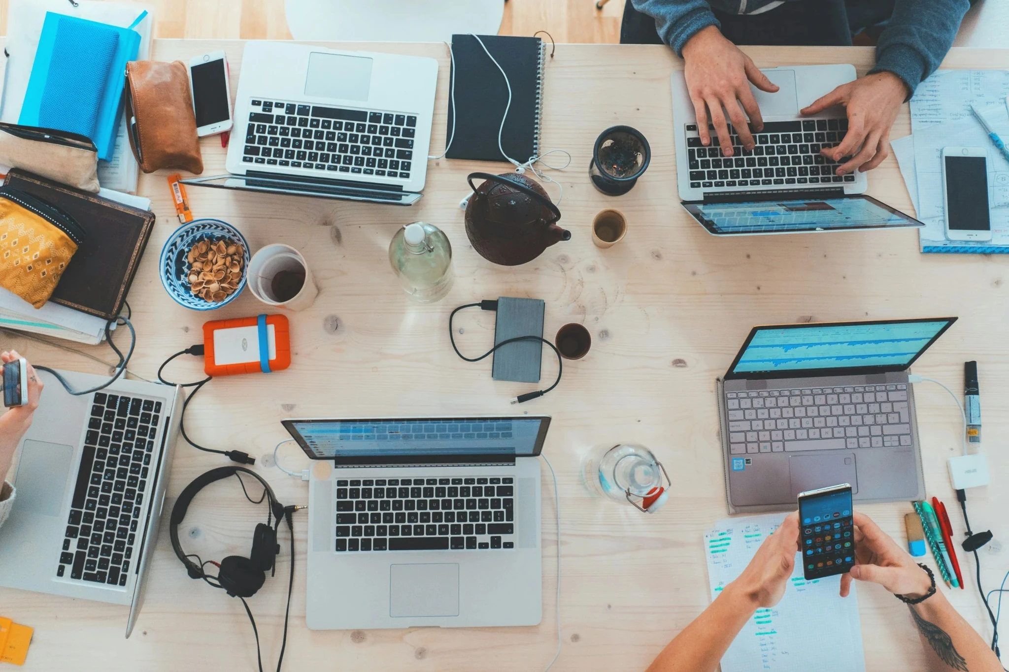 People working with laptops and mobile devices at a desk